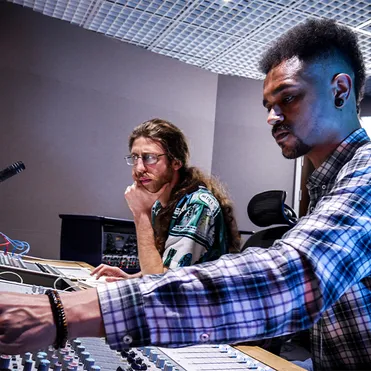 Music producing students in a recording studio.
