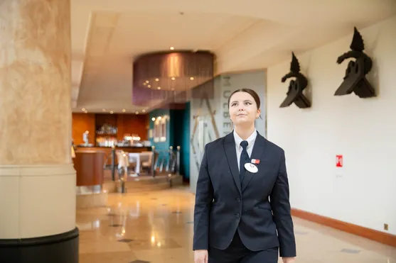 Student, Esme, is stood, wearing uniform, in a hotel lobby.