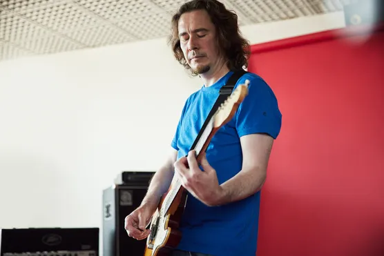 Lecturer, Alun Tomos, playing a guitar