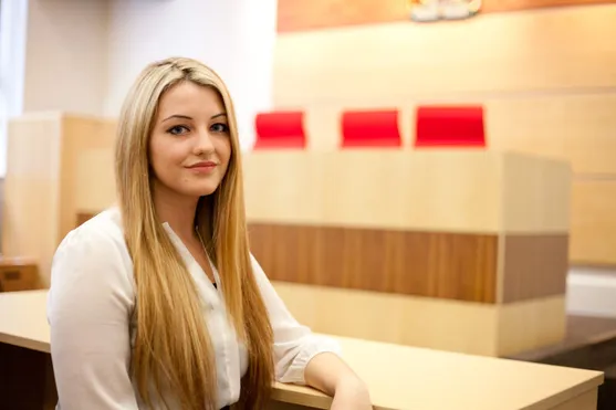 A student stood in the moot court in treforest, smiling at the camera
