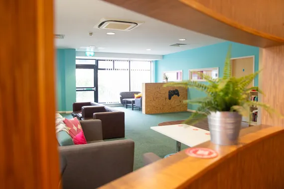 communal seating area with sofas, a table and plants in Newport halls of residence