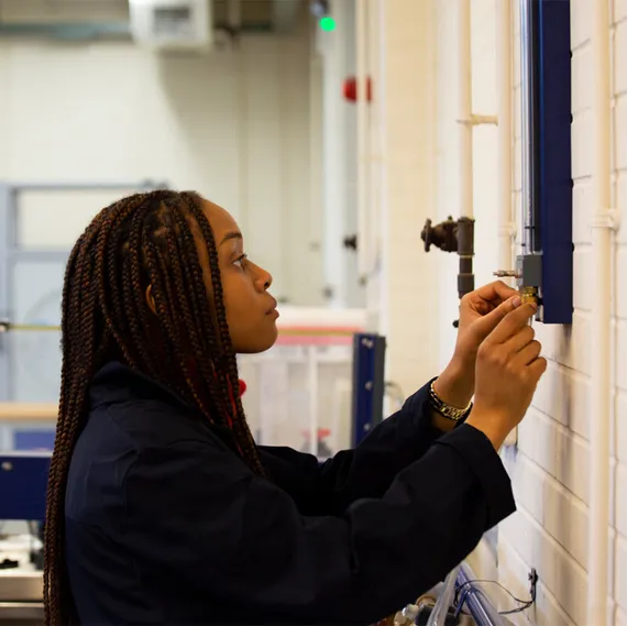 A student uses a control on the wall of a civil engineering workshop to assist with a practical experiment at USW Treforest