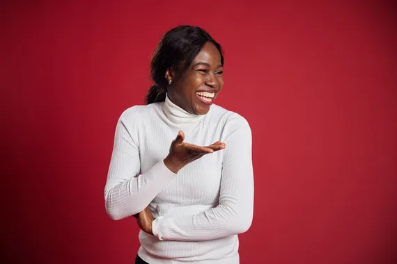Student Chidinma Fofah laughs in front of a red backdrop
