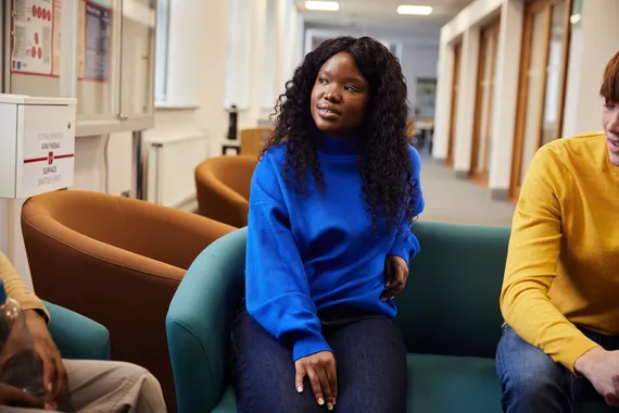 A student listening to a group discussion in the library.
