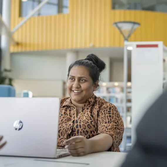 student sat at a table with laptop