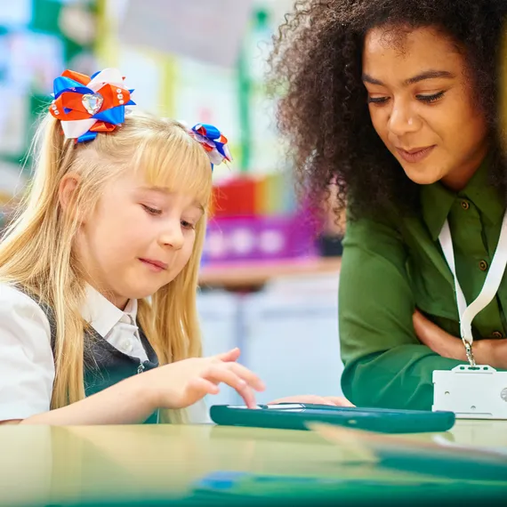Girl using ipad with teacher