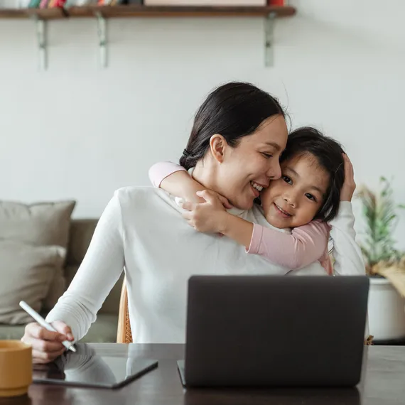 Woman working on laptop with child