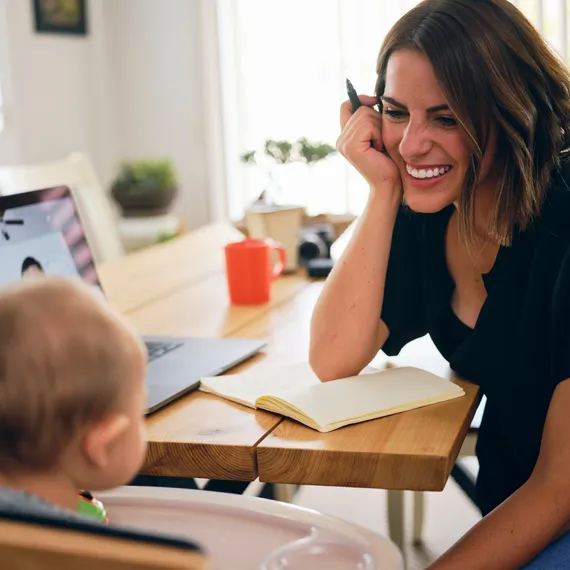 Woman working whilst looking after baby