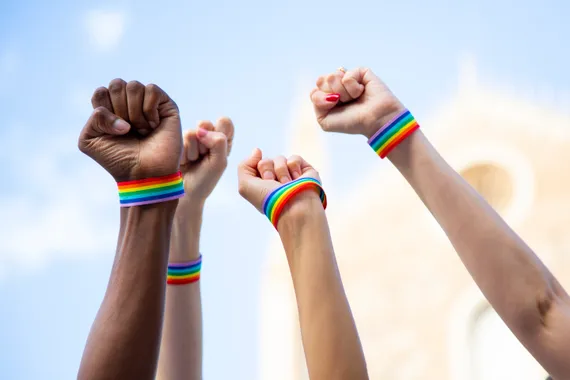 Four fists claiming pride rights with pride bracelet