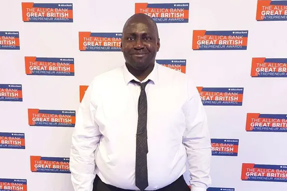 Victor Ajabo smiling at the camera, against a backdrop displaying the Entrepreneur Awards logo