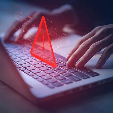 A red warning triangle sitting on top of laptop keyboard