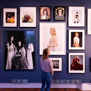 Image by David Parry. A person admiring photos on a gallery wall