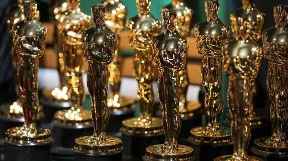 Cerfluniau aur Oscar wedi'u trefnu ar fwrdd