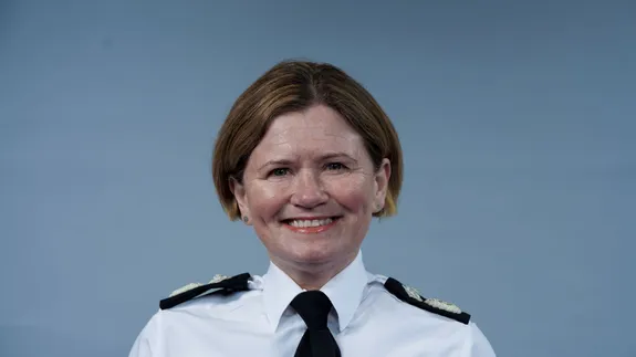A smiling woman wearing a police uniform