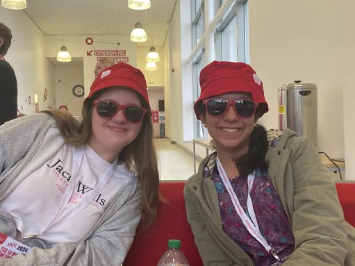 two students wearing University of South Wales bucket hats and sunglasses