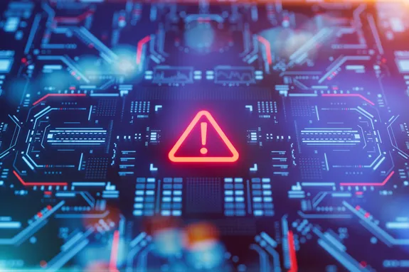 Close-up view of an illuminated circuit board with a prominent red warning triangle symbol in the centre