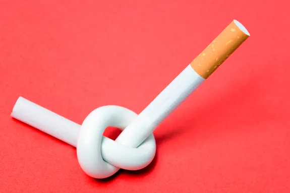 The image shows a single cigarette tied into a knot in the middle. This visual symbolizes the concept of quitting smoking.