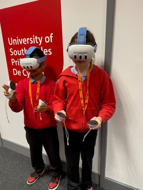 Two school children using the VR headsets and handsets from Goggleminds