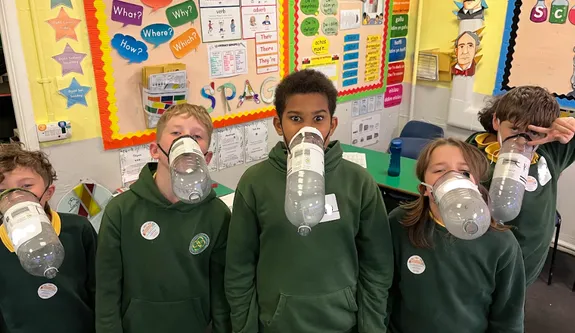 A group of pupils who attended the STEM sessions wearing gasmasks made from plastic bottles