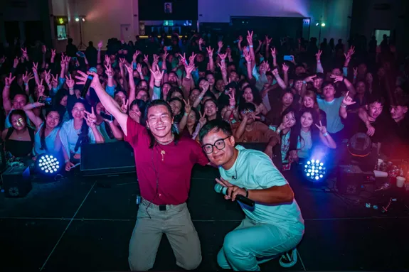 Karma and his friend performing on stage in front of a large crowd