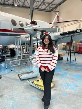 Khadijatul Kaba, in an aircraft hangar at the University of South Wales, stood in front of a propeller aircraft.