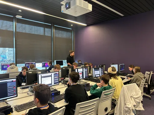 Students sitting in front of computer screens in a cyber laboratory at the University of South Wales