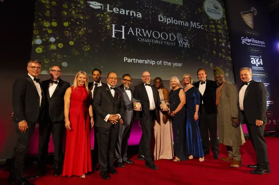 A group of people on stage collecting an award