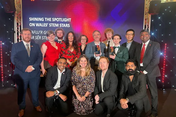 USW staff and students celebrate success at the Wales STEM Awards, posing with award trophies.