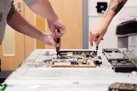 Two students working with a computing motherboard.