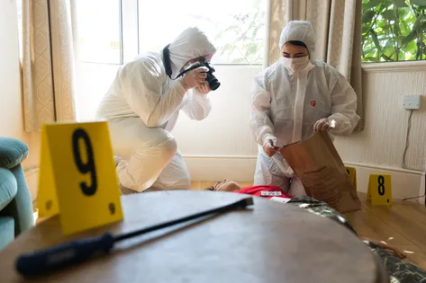 Forensic students photographing crime scene training scenario.