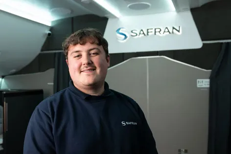 Thomas Vagi standing in front of the Safran Seats company logo