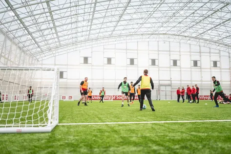 A football match is taking place on the indoor pitch at USW Sport Park.