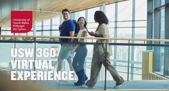 Three students walking across a bridge-like walkway inside the USW Newport campus.