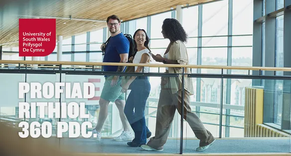 Three students walking across a bridge-like walkway inside the USW Newport campus.