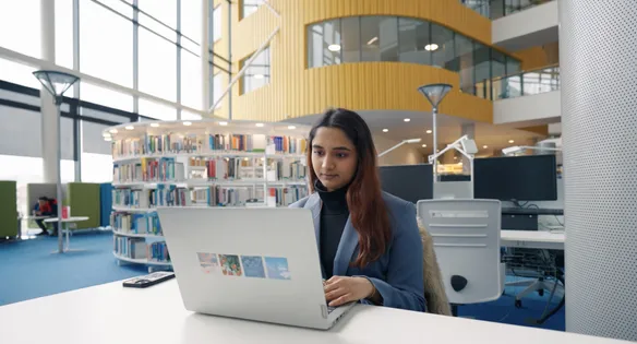 A student sat in newport library on her laptop