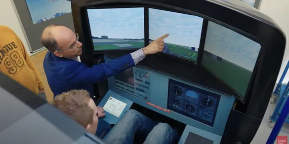 Still from aeronautical course video - student and lecturer inside of the simulator