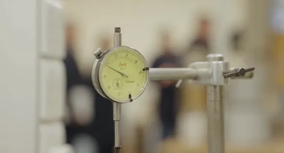 A close-up of a round pressure-style gauge on a piece of civil engineering equipment that measures in 0.01mm in a civil engineering workshop at the Treforest campus