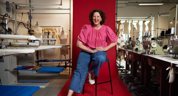 Lecturer sat in front of a red backdrop in fashion studios