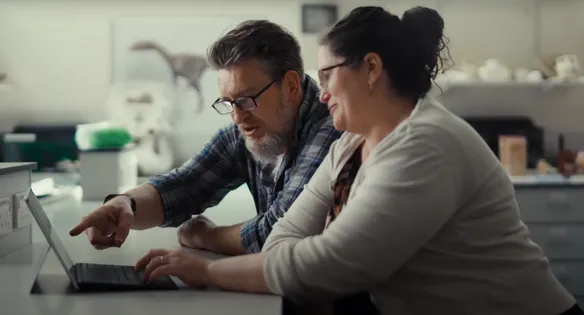 Two people looking at pointing laptop screen