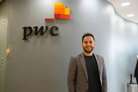 Computing graduate, Hamed, poses for a photo in his workplace