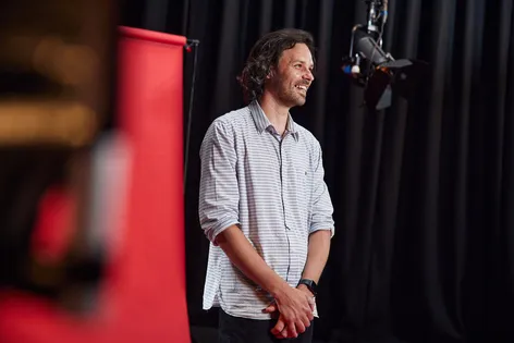 Staff stood in front of red backdrop in a film studio smiling