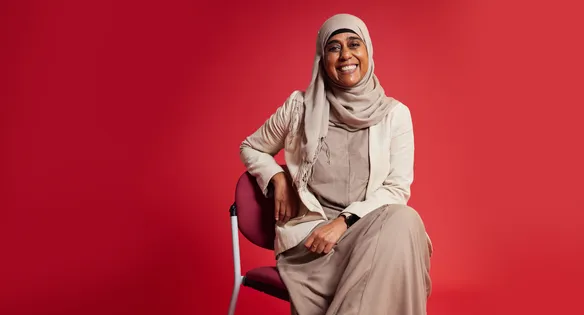 Staff sat in front of a red backdrop smiling