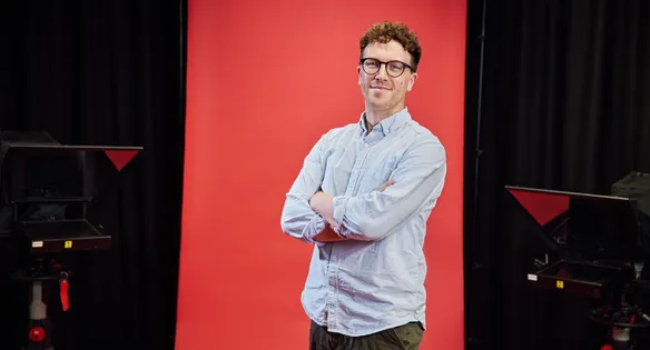 Staff stood in front of a red backdrop smiling