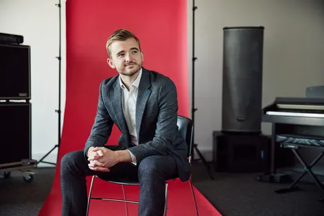 Staff sat in front of a red backdrop smiling