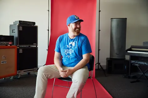 Staff sat in front of a red backdrop smiling