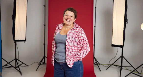 Staff stood in front of a red backdrop in a photography studio