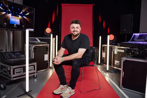 Staff sat in front of a red backdrop smiling