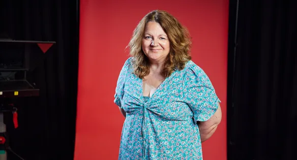 Staff stood in front of red backdrop in a film studio smiling