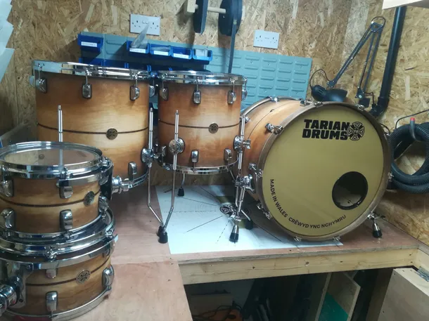 a brown wooden tarian drum set sitting on a work bench