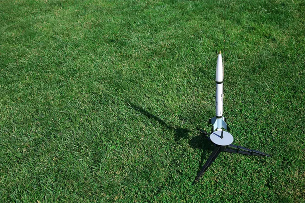 Small rocket standing on grass ready for lift off